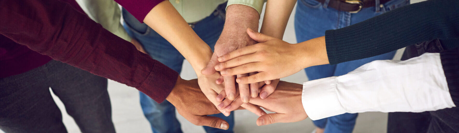 People Of Different Ages And Nationalities Fold Their Arms As A Symbol Of Cooperation.